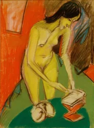 Nudo femminile in piedi al tavolo