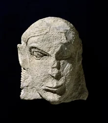 Civiltà etrusca: testa di donna in calcare. 650 a.C. circa. Dal tumulo della Pietrera di Vetulonia. Firenze, Museo Archeologico