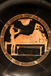 Coppa: simposiasta e giovane schiavo che suona il doppio aulos (ceramica a figure rosse,)