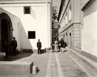 Uomini in uniforme che accompagnano una donna elegantemente vestita verso la chiesa della fattoria di Lo Zucco, Sicilia, 1900