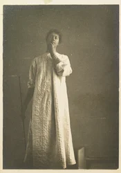 Donna in camicia, mano davanti alla bocca
