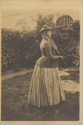 Donna con racchetta, in un giardino