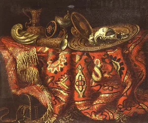 Una coppa di nautilus, una patena, brocche e un piatto dorato su un tappeto drappeggiato su un bordo