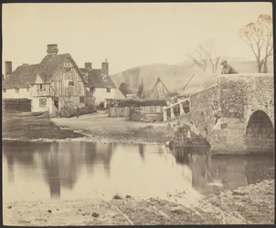 [Veduta di una casa al di là di un fiume con un ponte sulla destra].