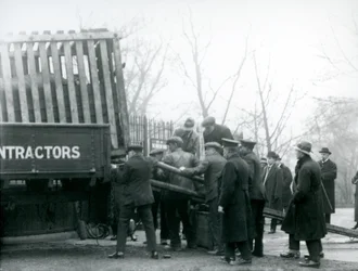 Una folla di spettatori osserva mentre un rinoceronte viene scaricato da un camion dai guardiani, Zoo di Londra, 1924