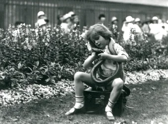 Una giovane ragazza Betty che tiene un serpente indaco orientale, seduta su un baule di pelle, Zoo di Londra, 1924