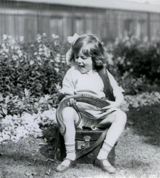 Una giovane ragazza Betty che tiene un serpente indaco orientale, mentre è seduta su un baule di pelle, Zoo di Londra, 1924