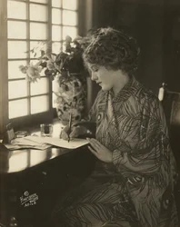 Mary Pickford, che indossa un kimono, scrive a una scrivania, c.1918