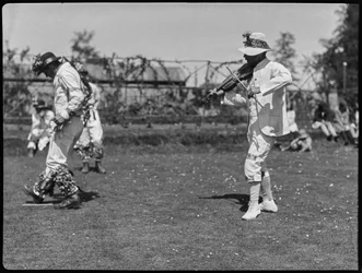 Un membro della troupe di Bampton Morris che si esibisce in una "Pipe Dance", accompagnato dal suonatore di violino