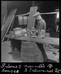 Frank Jones al lavoro per dipingere un pannello decorativo, XX secolo (foto)
