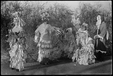 Persone in costume che si esibiscono in una rappresentazione di Mummers