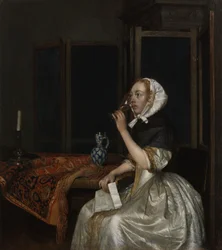 Giovane donna con un bicchiere di vino, con una lettera in mano