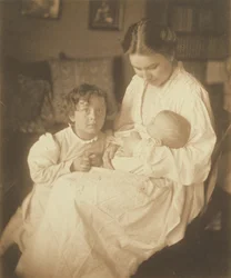 [Madre in vestaglia, seduta, con neonato e figlio piccolo].