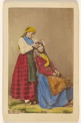 [Donna anziana che acconcia i capelli di una donna più giovane].
