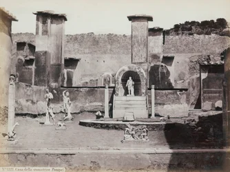 Vista parziale del giardino elevato della Casa di Marco Lucrezio a Pompei, decorato con statue di marmo e erme. Al centro una fontana con una nicchia. Sullo sfondo frammenti di affreschi
