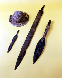 Armi di un guerriero longobardo: scudo ombrello, pugnale, spada e punta di lancia. Museo di Cividale del Friuli