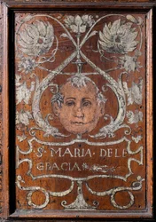 Piatto di legno decorato con un volto e l