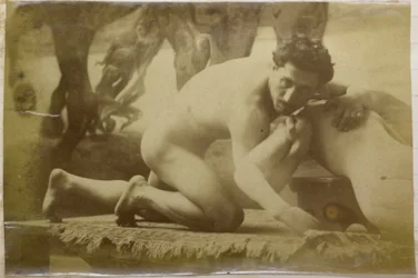 Studio di un modello maschile nudo, sdraiato a terra e lottando con un manichino, nell