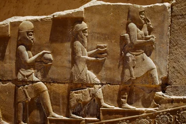 Scultura in rilievo di uomini che portano offerte sui muri di Persepoli. Persepoli, Iran