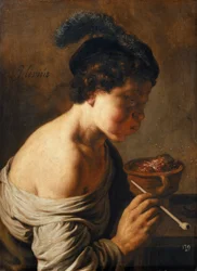 Un giovane che soffia sui carboni.
