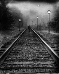 Un uomo sui binari avvolti dalla nebbia