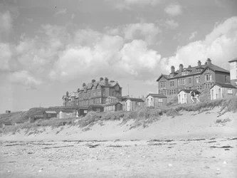 Veduta dalla spiaggia di Silloth di capanne e case lungo il mare; paesaggio marino; fronte