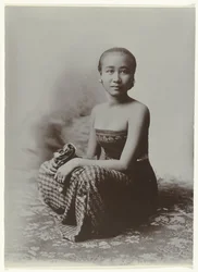 Ritratto in studio di una giovane donna giavanese seduta in un sarong con motivo batik