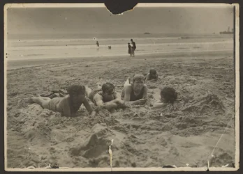 [Bambini che si sdraiano sulla sabbia della spiaggia]