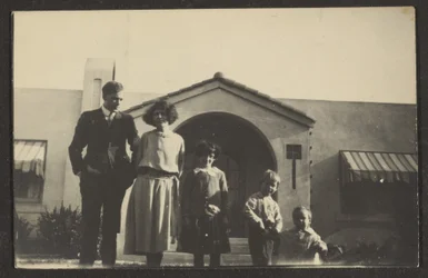 Ritratto di famiglia davanti a una casa