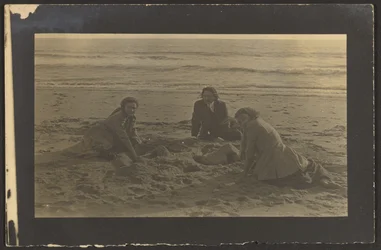 [Figure sedute sulla spiaggia]