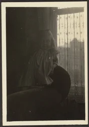 [Bambina appoggiata allo schienale della sedia]