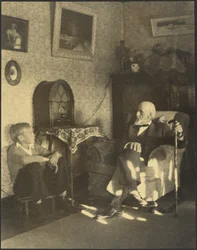 [Uomo e ragazzo seduti in uno studio]