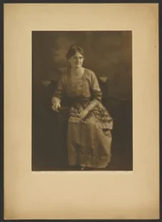 [Ritratto di donna seduta in abito con accenti di nastro].