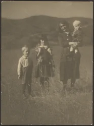 [Donna e tre bambini in un campo]