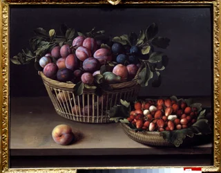 Una pesca, fragole e un cesto di frutta