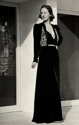 Modella indossa un lungo abito da sera di velluto scuro con decorazione ricamata, creato dalla casa di moda italiana "Fercioni".