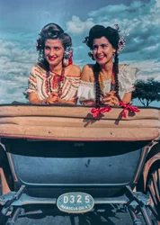 Giovani donne nicaraguensi posano in costumi festivi e copricapi sul retro di una carrozza