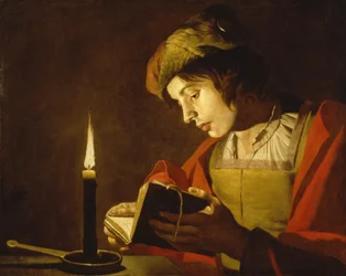 Giovane uomo che legge alla luce di una candela