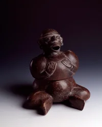 Arte precolombiana, civiltà Maya, periodo iniziale: vaso antropomorfo in argilla che raffigura un uomo seduto con le mani sul petto che indossa una maschera di scimmia con la bocca aperta. Da Uaxactun, Guatemala. Guatemala, Museo Nazionale di Archeologia