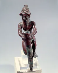 Figura di fondazione in rame raffigurante un dio che spinge un chiodo