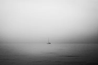 Barca a vela solitaria nella nebbia