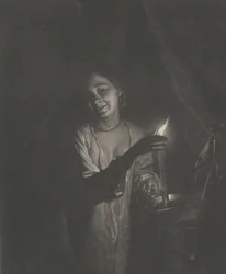 Giovane donna che tiene una candela in una camera da letto