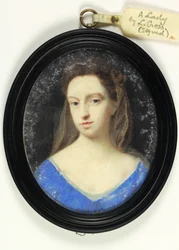 Una signora in corpetto blu con cappuccio marrone
