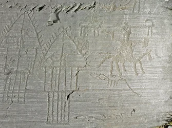 Preistoria, civiltà dei Camuni, arte rupestre: roccia tombale con scene di vita quotidiana in un villaggio, capanna su palafitte, case sul lago, cani, uccelli, cervi e uomo a cavallo