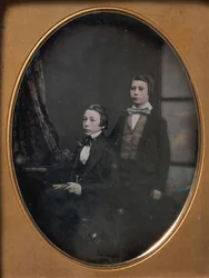 Due giovani uomini con papillon, uno seduto con un libro, uno in piedi, 1850s