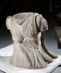 Torso scolpito di un cavaliere con mantello pesante usurato