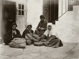 Donne che macinano farina con macine rotonde nel cortile di una casa a Gerusalemme, 1867