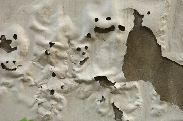 Italia, Toscana, Firenze, facce di fantasmi sorridenti su muro dipinto e logorato, 2022 (foto)