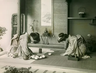 Due donne giapponesi in costume tradizionale si salutano prima della cerimonia del tè, circa 1900 - 1915 (fotografia)