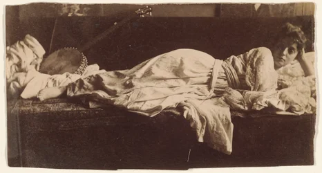 Blanche Gilroy in costume classico, sdraiata con banjo